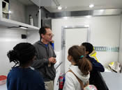 EPA Scientist discussing macroinvertebrates with students inside the Mobile Lab.