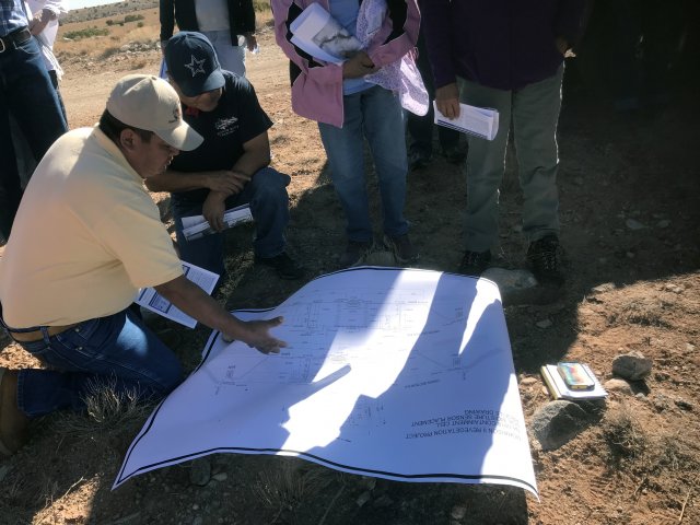 Diné Uranium Remediation Advisory Commissioners review engineering drawings of reclamation work performed by the Navajo Abandoned Mine Lands Program