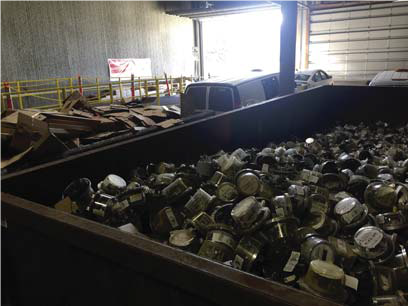 This is a picture of recycling materials inside a large, brown container inside a warehouse.