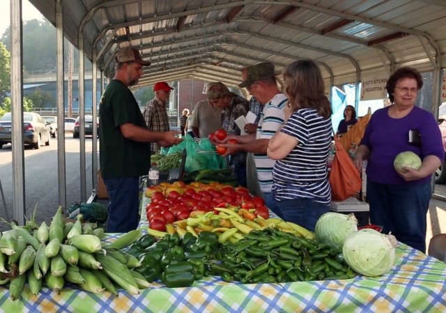 Farmers market with people buying and selling fresh produce