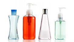 A row of four plastic containers of varying shapes holding different liquids