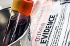 Two full blood vials sitting in a container next to a bag labeled "Evidence"