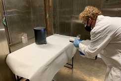 Jonathan Sawyer can be seen spraying down a metal trash can in order to test the ability of the spray device to wrap around and deposit on the sides and back of a cylindrical object.