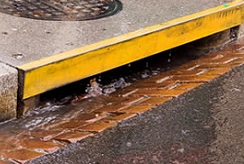 water pours into an urban storm drain
