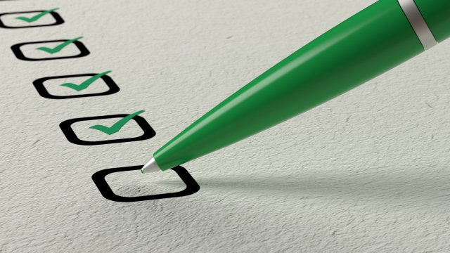 This is a picture of a green pen checking a box on a piece of paper. There are four other green checks in boxes on the paper. 