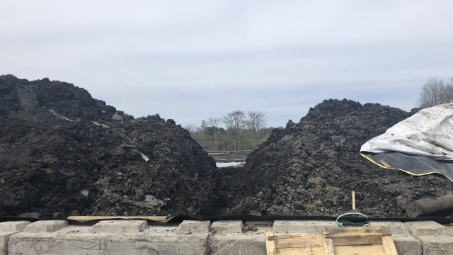 Soil waste pile is uncovered for loading and disposal