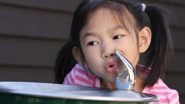 Photo of a child drinking from a water fountain.