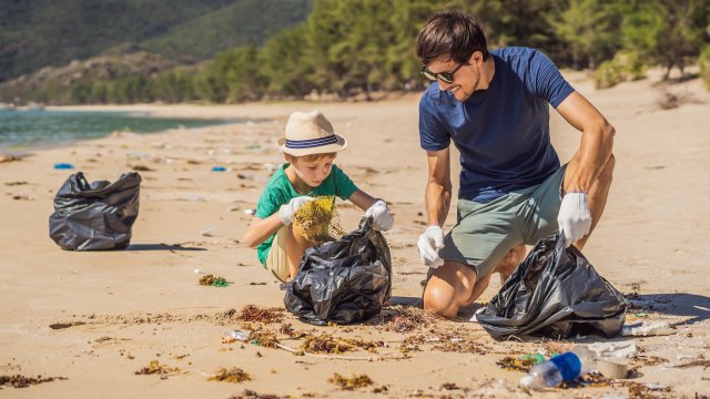 father and son cleaning up beach