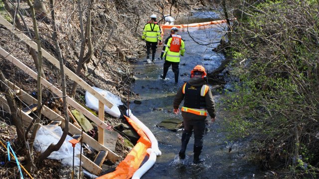 EPA workers check containment booms during culvert cleanout oversight