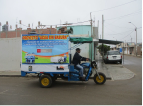 vehicle with a Spanish billboard warning of water pollution from trash