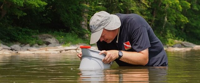 Man in water sampling water specimens