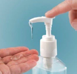 this is a picture of a person pushing down on the nozzle of a bottle of hand sanitizer