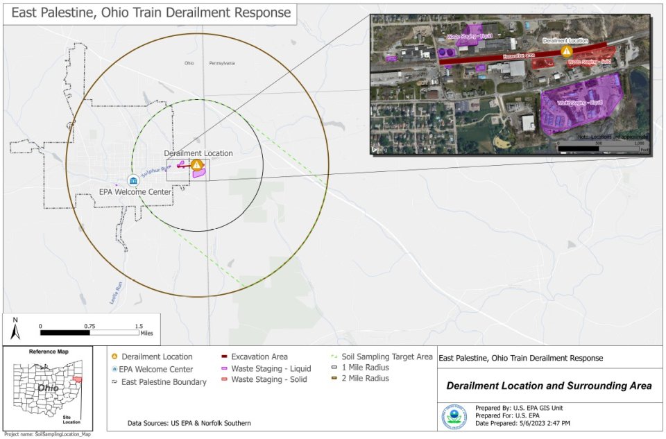 The Ohio Train Derailment Response location. The derailment location is labeled with an orange circle with an exclamation point and the EPA welcome center is labeled with a white circle with a blue building. Around the derailment location, there is a 1-mile radius circle in black and a 2-mile radius circle in brown. The soil sample target area is labeled with green dash marks and the East Palestine boundary is labeled with gray dash marks.