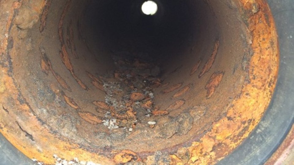 An interior shot of a water pipe, showing corrosion on the surface.
