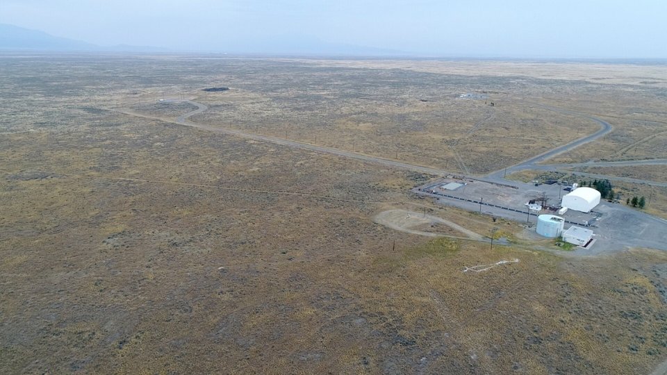 Wide overhead shot of the WSTB site, with the facility in the lower right and open landscape stretching out beyond it.