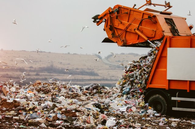 Image of garbage truck dumping waste in landfill. 