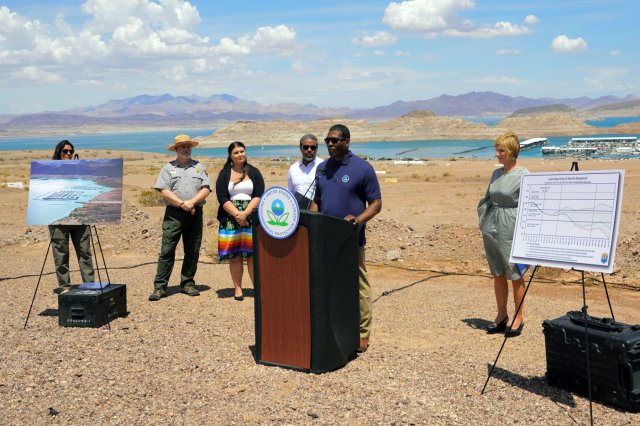 Pacific Southwest Regional Administrator Martha Guzman stands at far left; Administrator Michael Regan is at the podium in front of Lake Mead where the receding water levels are a stark example of climate change.