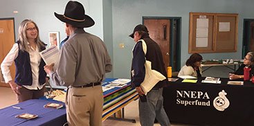 Information booths set up for public outreach by NNEPA and U.S. NRC with local residents asking talking with outreach representatives.