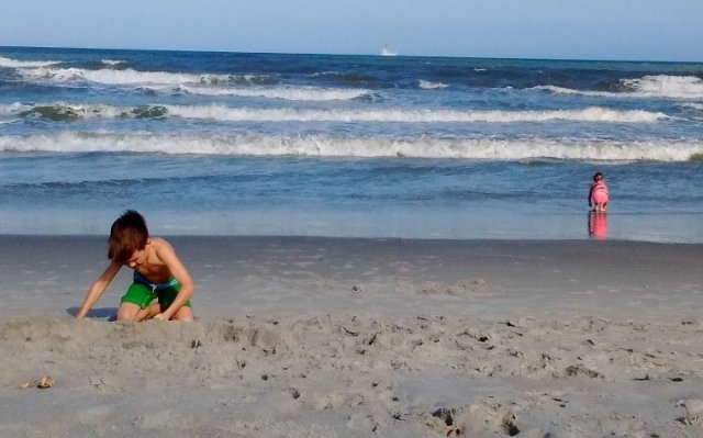 child plays at the beach