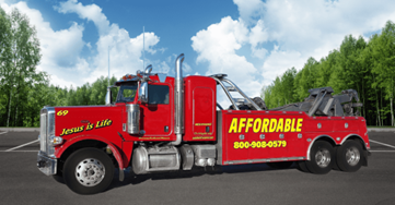 Large red diesel towing vehicle with affordable towing signage