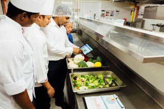 Image of a group of chefs in a kitchen preparing food. 