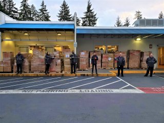 Group of Microsoft employees standing in front of boxes by the loading bay of a building. 