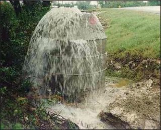Photo showing sewage and water overflowing from a manhole.