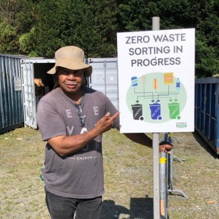 Image of man holding a sign for zero waste sorting. 
