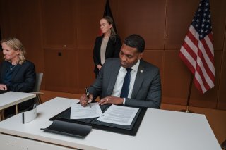 EPA Administrator Michael S. Regan signing a document. Also pictured, German Environment Minister Steffi Lemke.
