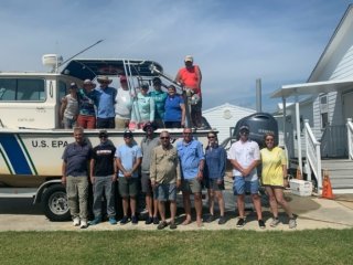 Research team poses for a group photo around an EPA boat