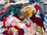 Pile of multicolored clothing in a waste pile