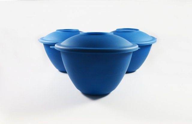 This picture is of three blue salad bowls. The bowls form a triangle, with the point of the triangle in the center and foreground of the picture, and the other two bowls behind, adjacent to each other.