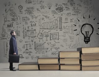 Stock photo schematic of an idea - a man approaching a lightbulb