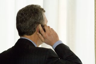 a man in a suit uses a cell phone