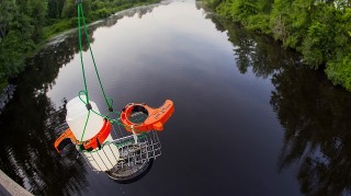 water monitoring equipment held above a river