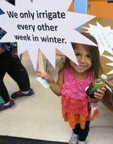 Little girl holding a We're for Water frame.