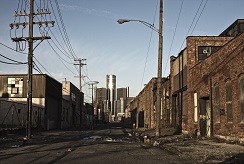 A street in Detroit with crumbling sidewalks and brick facades