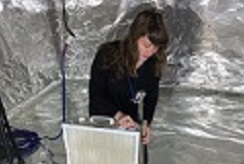 EPA researcher Heidi Vreeland tests a DIY air cleaner made from a filter attached to a box fan.