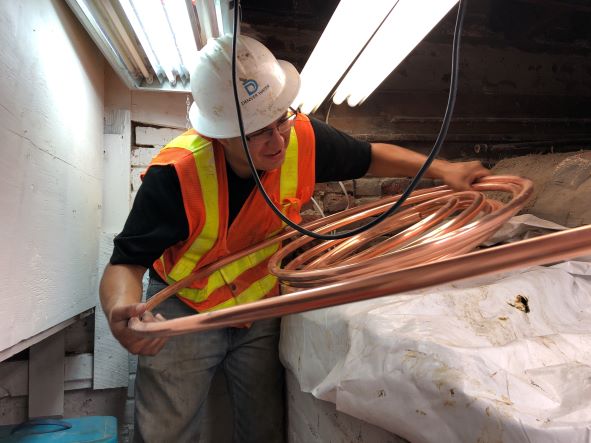 Worker holds replacement copper water line