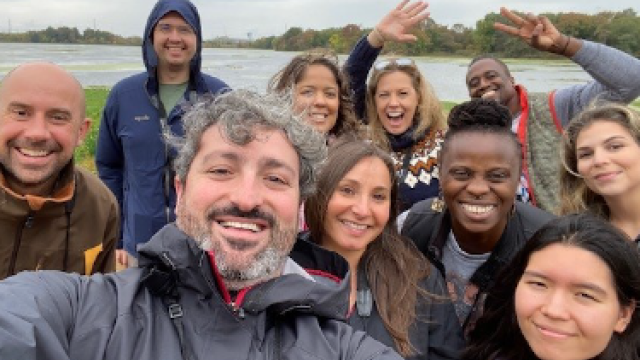 A group of EPA employees in the outdoors on a cloudy day standing in front of a lake.