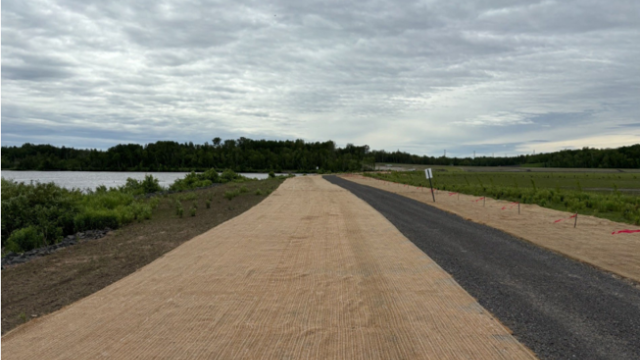 Maintenance seeding and erosion control blanketing are installed alongside the pedestrian trail. 