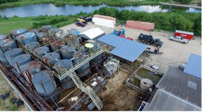 Oil tanks in foreground with pond in background