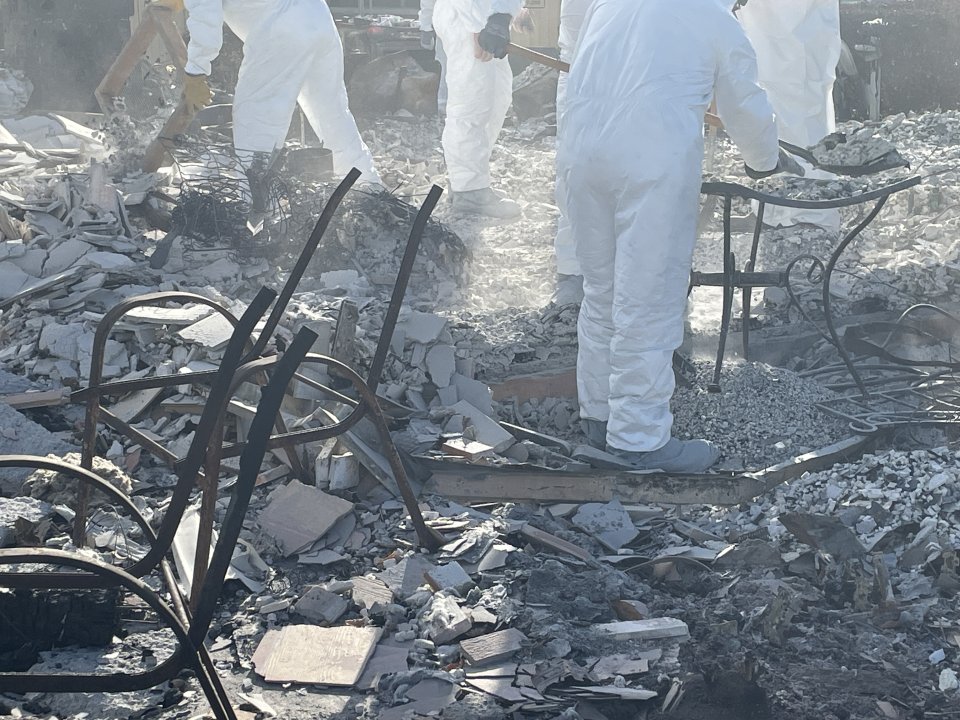 Crews sifting through an unsprayed ash and debris footprint on Oct. 13.