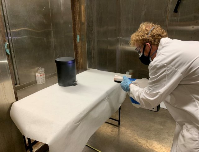 Jonathan Sawyer can be seen spraying down a metal trash can in order to test the ability of the spray device to wrap around and deposit on the sides and back of a cylindrical object.