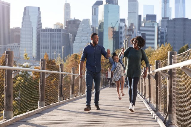 Family on a bridge with city in the background