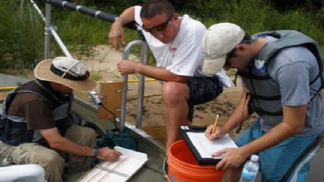 Three scientists collecting and documenting samples