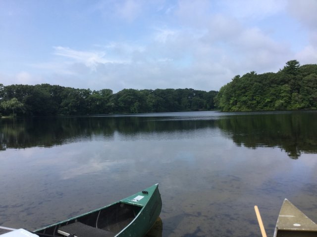 Lake in Rhode Island with tips of two canoes in the foreground