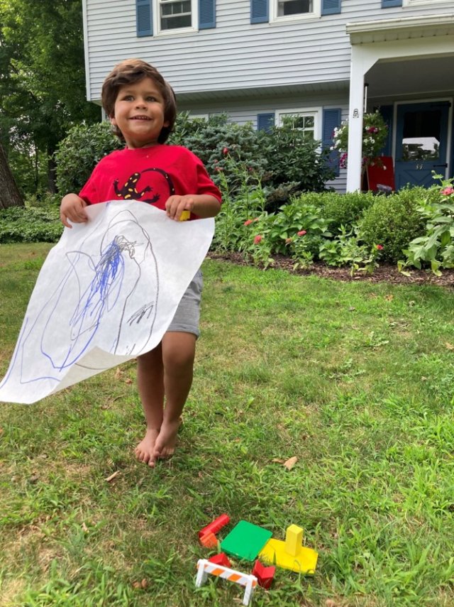 Photo of child holding drawing of a septic system