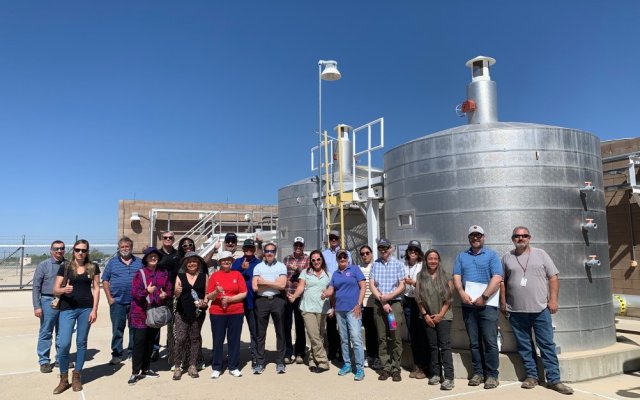 People standing in front of a groundwater treatment system