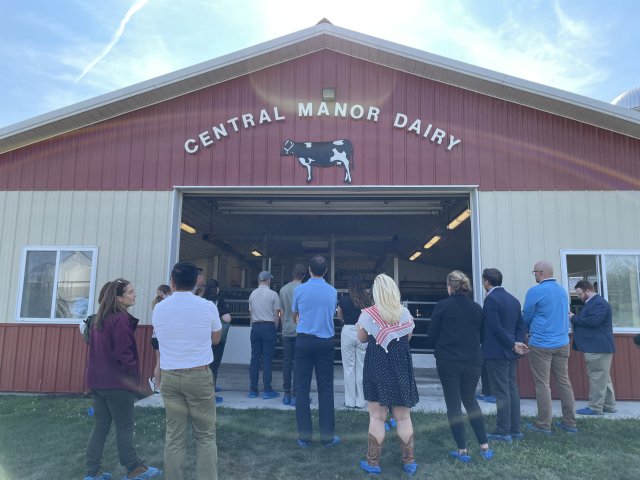 People are seen standing in front of a farm